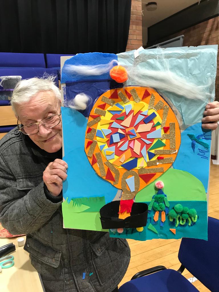 A person holds up a collaged image of a hot air balloon